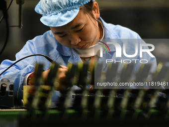 An employee works on a circuit board production line at the workshop of Anhui Shixin Electronic Technology Co LTD in Fuyang, China, on Novem...