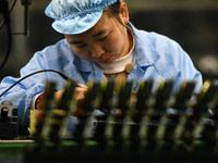 An employee works on a circuit board production line at the workshop of Anhui Shixin Electronic Technology Co LTD in Fuyang, China, on Novem...