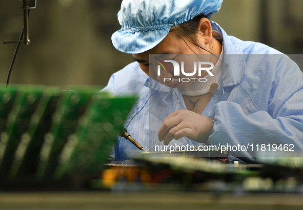 An employee works on a circuit board production line at the workshop of Anhui Shixin Electronic Technology Co LTD in Fuyang, China, on Novem...