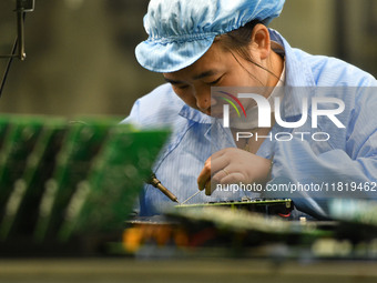 An employee works on a circuit board production line at the workshop of Anhui Shixin Electronic Technology Co LTD in Fuyang, China, on Novem...