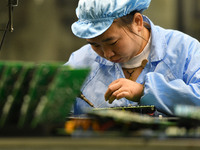 An employee works on a circuit board production line at the workshop of Anhui Shixin Electronic Technology Co LTD in Fuyang, China, on Novem...