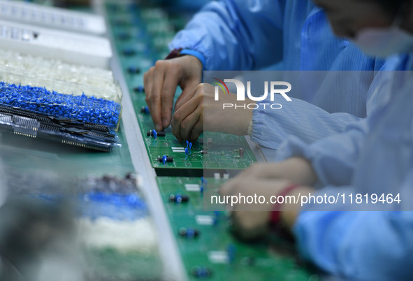 An employee works on a circuit board production line at the workshop of Anhui Shixin Electronic Technology Co LTD in Fuyang, China, on Novem...