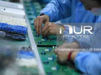 An employee works on a circuit board production line at the workshop of Anhui Shixin Electronic Technology Co LTD in Fuyang, China, on Novem...