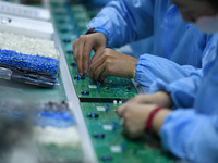 An employee works on a circuit board production line at the workshop of Anhui Shixin Electronic Technology Co LTD in Fuyang, China, on Novem...