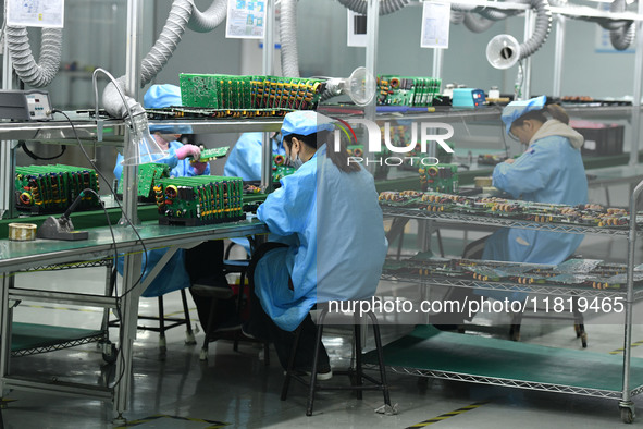 Employees work on a circuit board production line at the workshop of Anhui Shixin Electronic Technology Co LTD in Fuyang, China, on November...