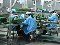 Employees work on a circuit board production line at the workshop of Anhui Shixin Electronic Technology Co LTD in Fuyang, China, on November...