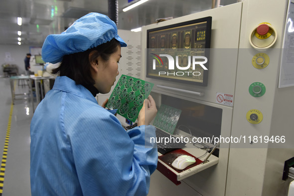 An employee works on a circuit board production line at the workshop of Anhui Shixin Electronic Technology Co LTD in Fuyang, China, on Novem...