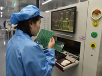 An employee works on a circuit board production line at the workshop of Anhui Shixin Electronic Technology Co LTD in Fuyang, China, on Novem...