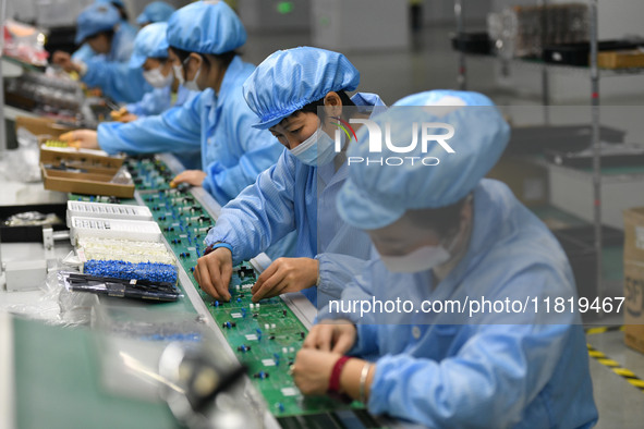 Employees work on a circuit board production line at the workshop of Anhui Shixin Electronic Technology Co LTD in Fuyang, China, on November...