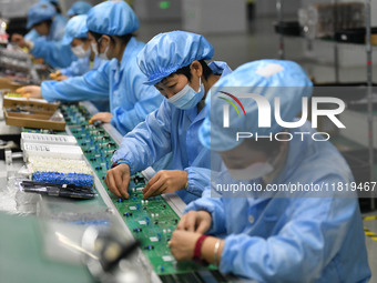 Employees work on a circuit board production line at the workshop of Anhui Shixin Electronic Technology Co LTD in Fuyang, China, on November...