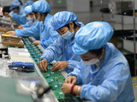 Employees work on a circuit board production line at the workshop of Anhui Shixin Electronic Technology Co LTD in Fuyang, China, on November...