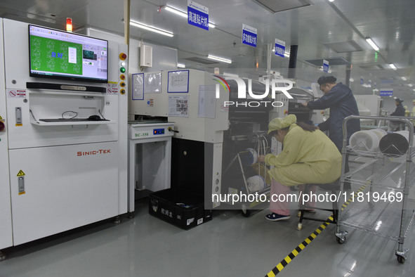 An employee works on a circuit board production line at the workshop of Anhui Shixin Electronic Technology Co LTD in Fuyang, China, on Novem...