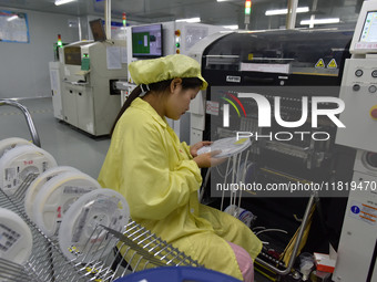 An employee works on a circuit board production line at the workshop of Anhui Shixin Electronic Technology Co LTD in Fuyang, China, on Novem...