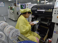 An employee works on a circuit board production line at the workshop of Anhui Shixin Electronic Technology Co LTD in Fuyang, China, on Novem...