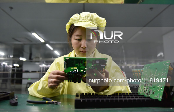 An employee works on a circuit board production line at the workshop of Anhui Shixin Electronic Technology Co LTD in Fuyang, China, on Novem...