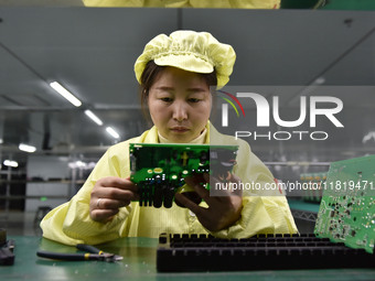 An employee works on a circuit board production line at the workshop of Anhui Shixin Electronic Technology Co LTD in Fuyang, China, on Novem...