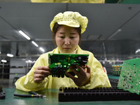 An employee works on a circuit board production line at the workshop of Anhui Shixin Electronic Technology Co LTD in Fuyang, China, on Novem...