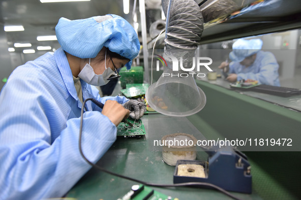 An employee works on a circuit board production line at the workshop of Anhui Shixin Electronic Technology Co LTD in Fuyang, China, on Novem...