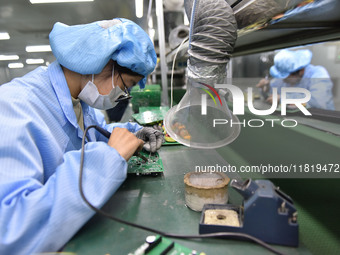 An employee works on a circuit board production line at the workshop of Anhui Shixin Electronic Technology Co LTD in Fuyang, China, on Novem...