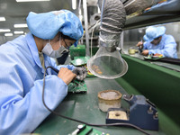 An employee works on a circuit board production line at the workshop of Anhui Shixin Electronic Technology Co LTD in Fuyang, China, on Novem...