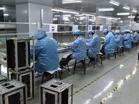 Employees work on a circuit board production line at the workshop of Anhui Shixin Electronic Technology Co LTD in Fuyang, China, on November...