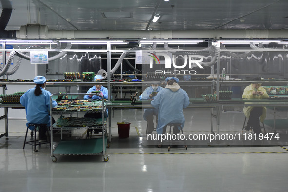 Employees work on a circuit board production line at the workshop of Anhui Shixin Electronic Technology Co LTD in Fuyang, China, on November...