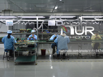 Employees work on a circuit board production line at the workshop of Anhui Shixin Electronic Technology Co LTD in Fuyang, China, on November...