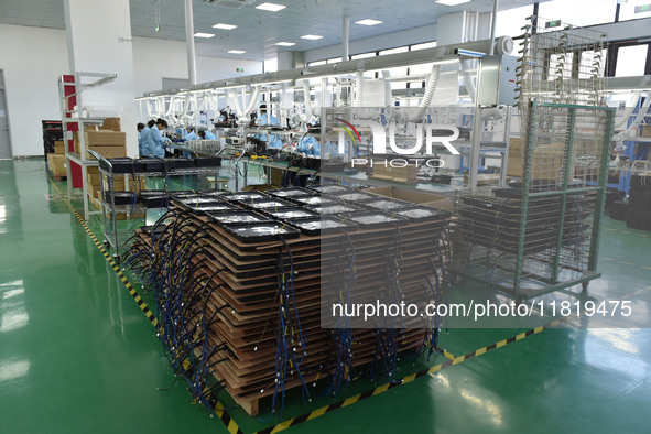 Employees work on a production line of wireless power supply products at the workshop of Zhonghui Chuangzhi (Fuyang) Technology Co., LTD in...