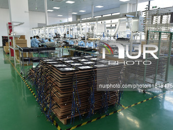 Employees work on a production line of wireless power supply products at the workshop of Zhonghui Chuangzhi (Fuyang) Technology Co., LTD in...