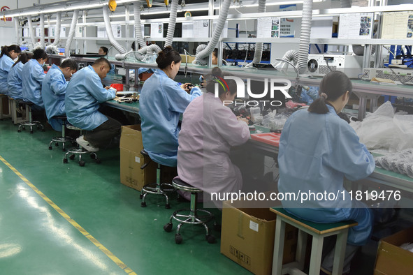 Employees work on a production line of wireless power supply products at the workshop of Zhonghui Chuangzhi (Fuyang) Technology Co., LTD in...