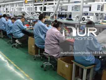 Employees work on a production line of wireless power supply products at the workshop of Zhonghui Chuangzhi (Fuyang) Technology Co., LTD in...