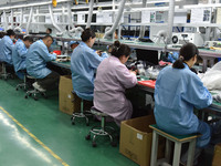 Employees work on a production line of wireless power supply products at the workshop of Zhonghui Chuangzhi (Fuyang) Technology Co., LTD in...