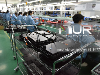 Employees work on a production line of wireless power supply products at the workshop of Zhonghui Chuangzhi (Fuyang) Technology Co., LTD in...