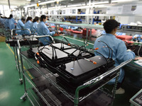 Employees work on a production line of wireless power supply products at the workshop of Zhonghui Chuangzhi (Fuyang) Technology Co., LTD in...