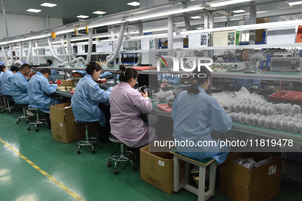 Employees work on a production line of wireless power supply products at the workshop of Zhonghui Chuangzhi (Fuyang) Technology Co., LTD in...