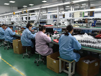 Employees work on a production line of wireless power supply products at the workshop of Zhonghui Chuangzhi (Fuyang) Technology Co., LTD in...