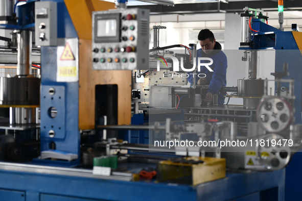 Employees work on a wire and cable production line at Anhui Aipu Huaton Electronic Technology Co LTD in Fuyang, China, on November 29, 2024....