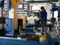 Employees work on a wire and cable production line at Anhui Aipu Huaton Electronic Technology Co LTD in Fuyang, China, on November 29, 2024....