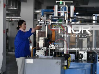 Employees work on a wire and cable production line at Anhui Aipu Huaton Electronic Technology Co LTD in Fuyang, China, on November 29, 2024....