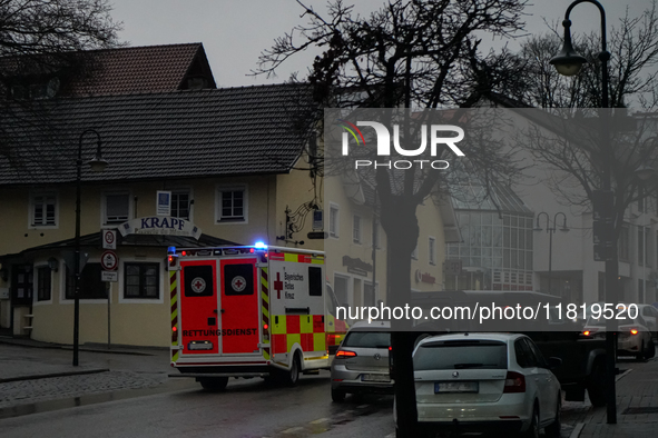 An ambulance from the Bavarian Red Cross navigates through the dimly lit Bahnhofstraße in Gauting, Germany, on January 5, 2022, with its lig...