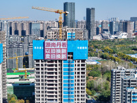 A large ''trade-in'' advertisement hangs on the outside of a commercial housing building under construction in Nanjing, China, on November 2...