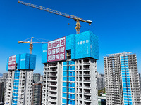 A large ''trade-in'' advertisement hangs on the outside of a commercial housing building under construction in Nanjing, China, on November 2...