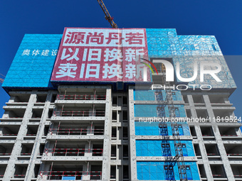 A large ''trade-in'' advertisement hangs on the outside of a commercial housing building under construction in Nanjing, China, on November 2...