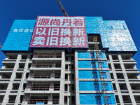 A large ''trade-in'' advertisement hangs on the outside of a commercial housing building under construction in Nanjing, China, on November 2...