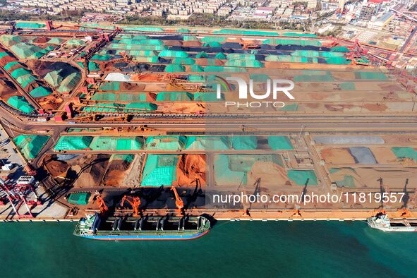 Imported iron ore is unloaded at a dock in Qingdao Port in Shandong province, China, on November 29, 2024. 