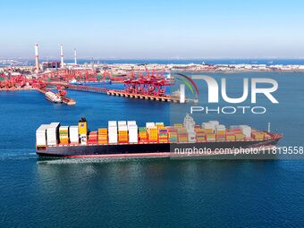 A cargo ship loaded with containers leaves the port of Qingdao in Qingdao, China, on November 29, 2024. (