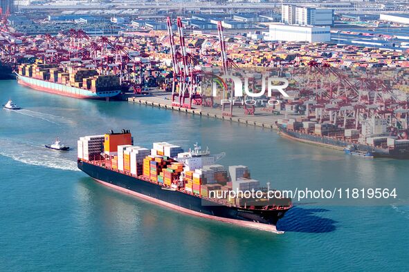 A cargo ship loaded with containers leaves the port of Qingdao in Qingdao, China, on November 29, 2024. 