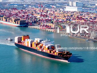 A cargo ship loaded with containers leaves the port of Qingdao in Qingdao, China, on November 29, 2024. (