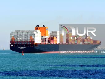 A cargo ship loaded with containers leaves the port of Qingdao in Qingdao, China, on November 29, 2024. (