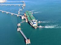 A foreign oil tanker prepares to leave the dock after unloading crude oil at the port of Qingdao in Shandong province, China, on November 29...